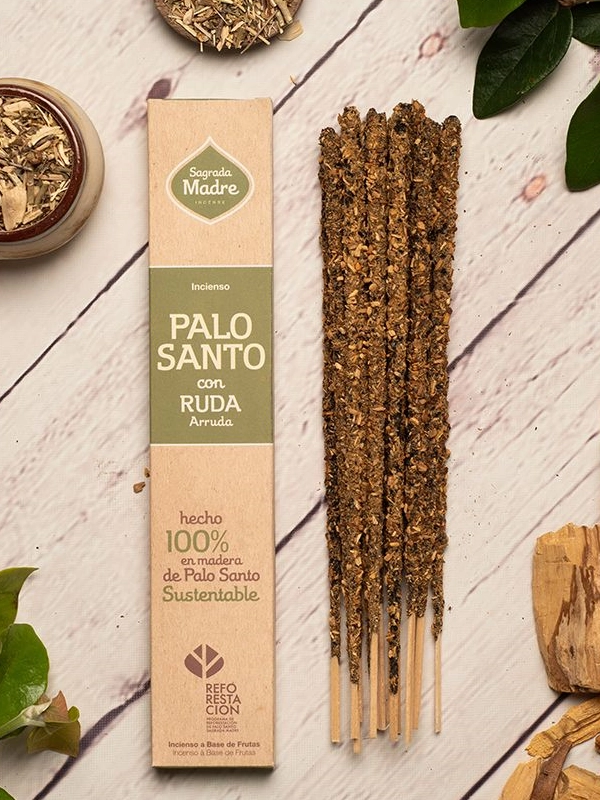 Varillas de incienso artesanal “Palo Santo con Ruda” de Sagrada Madre — hechas al 100% con madera de Palo Santo sostenible y hierba de ruda fresca. Ideal para rituales de protección energética, limpieza de ambientes y alejar energías negativas. Presentadas sobre fondo de madera blanqueada con hojas verdes y virutas naturales, sin químicos ni aditivos. Exclusivo en Incenseshop.online.